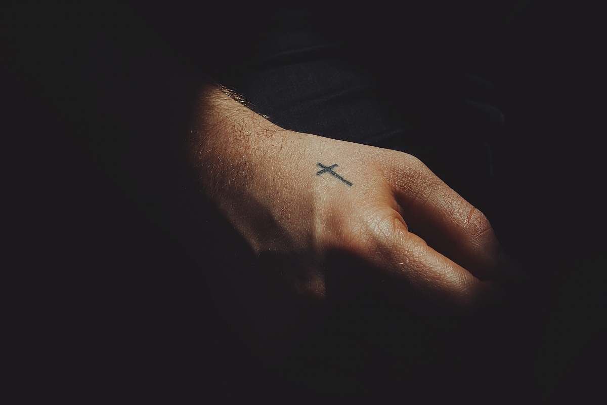 person black ink cross arm tattoo skin