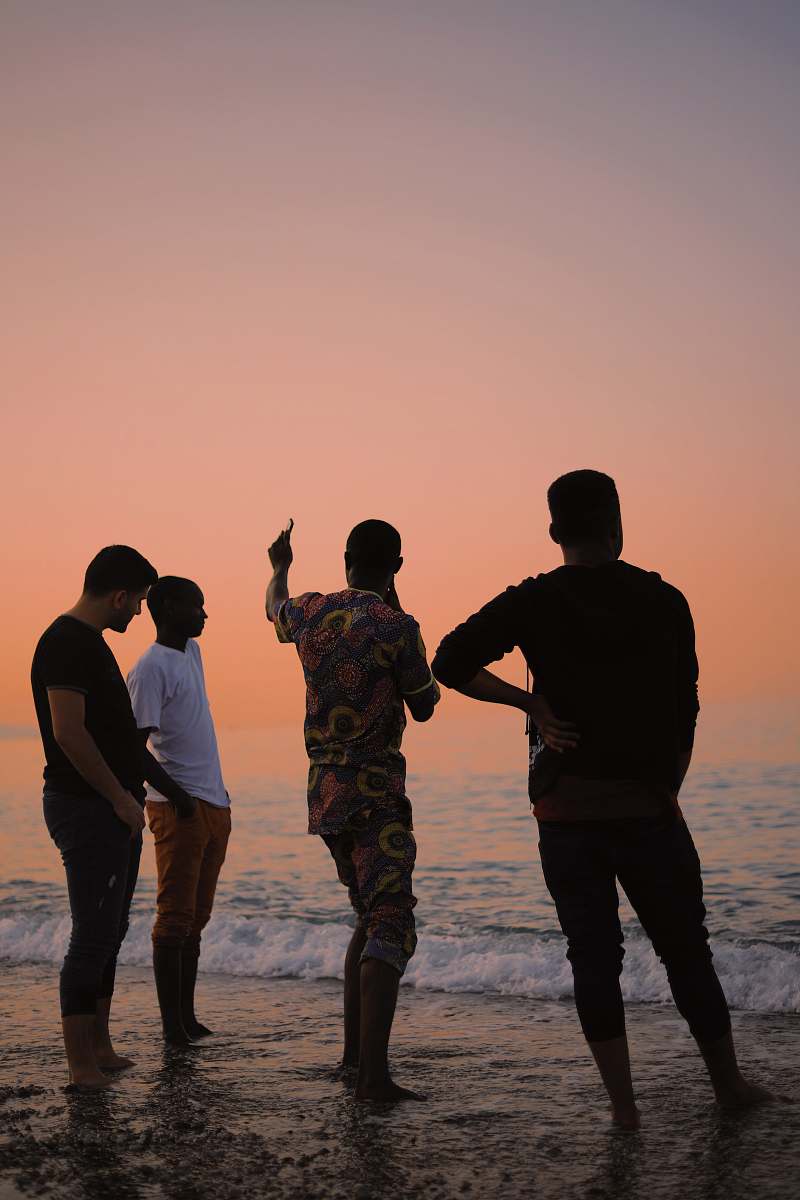 person four people standing on shore people