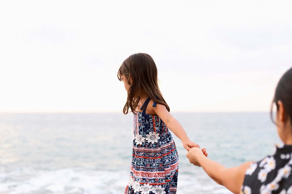 person girl holding girl overlooking body of water at daytime apparel