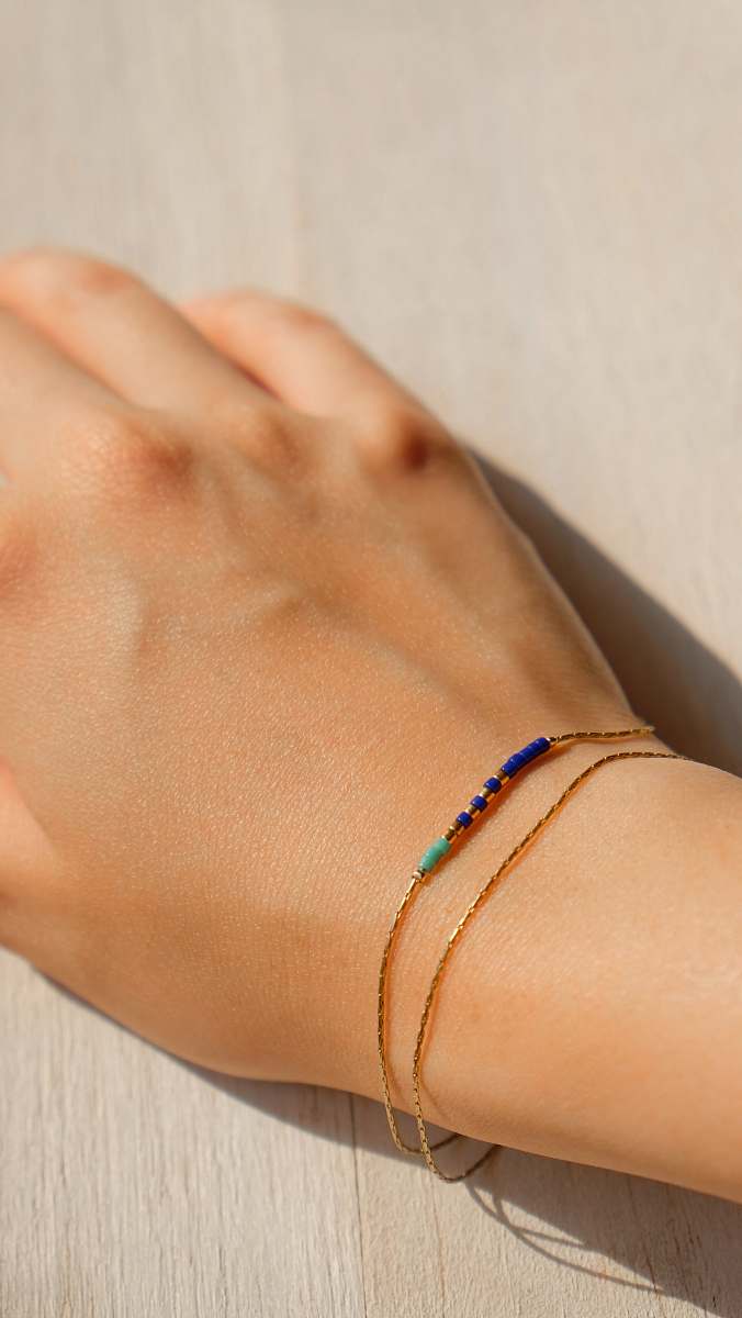 person gold-colored bracelet hand