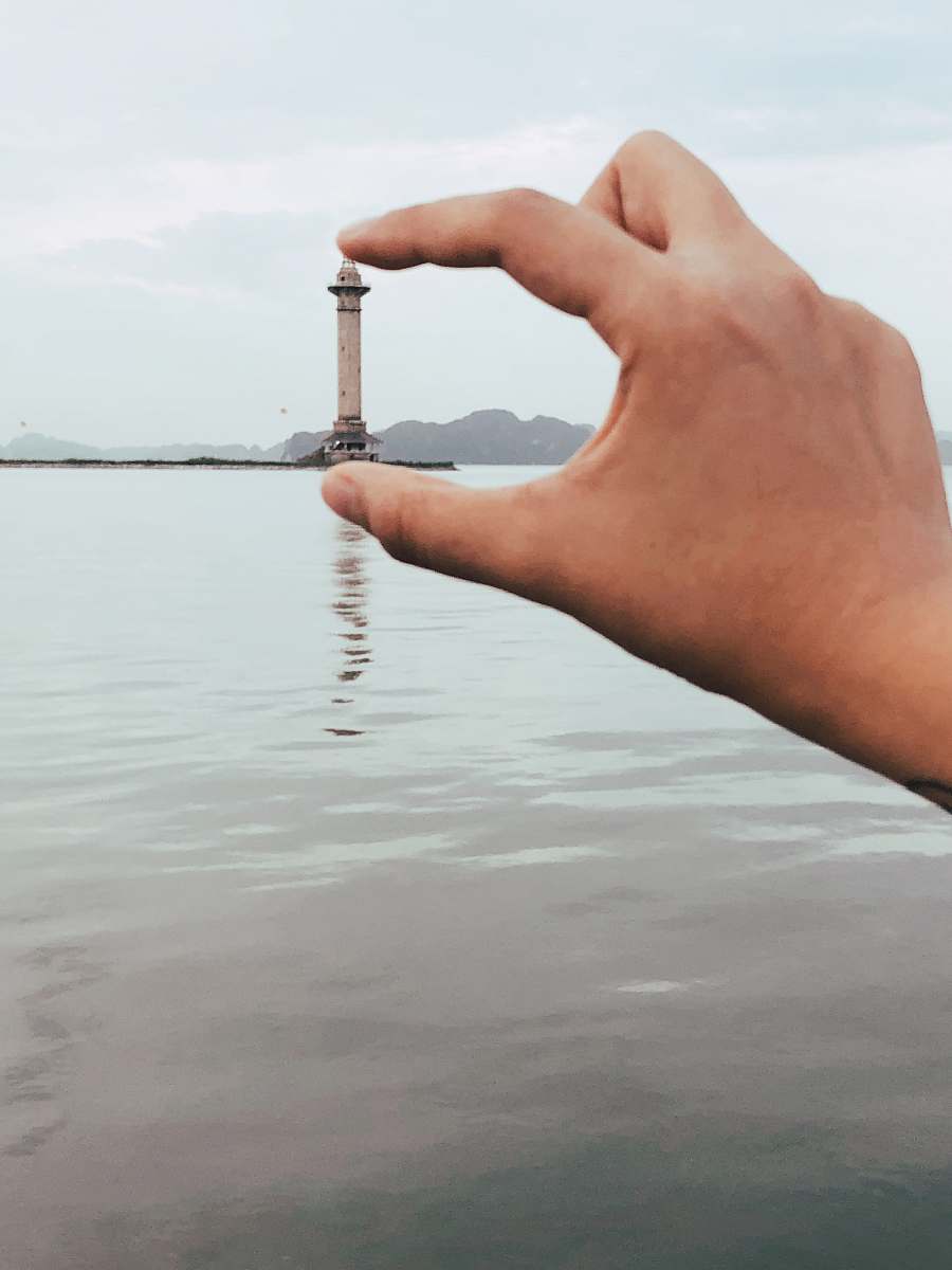 person gray lighthouse water