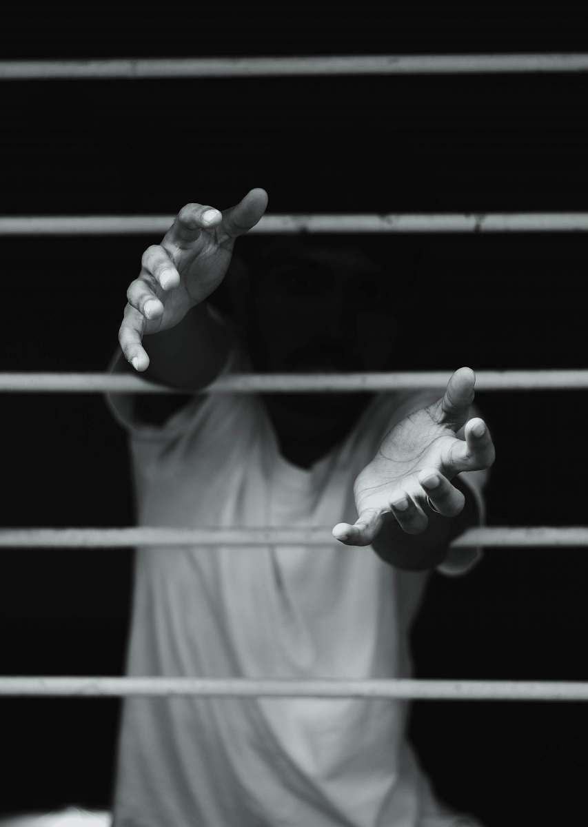 person grayscale photography of man in front of window finger