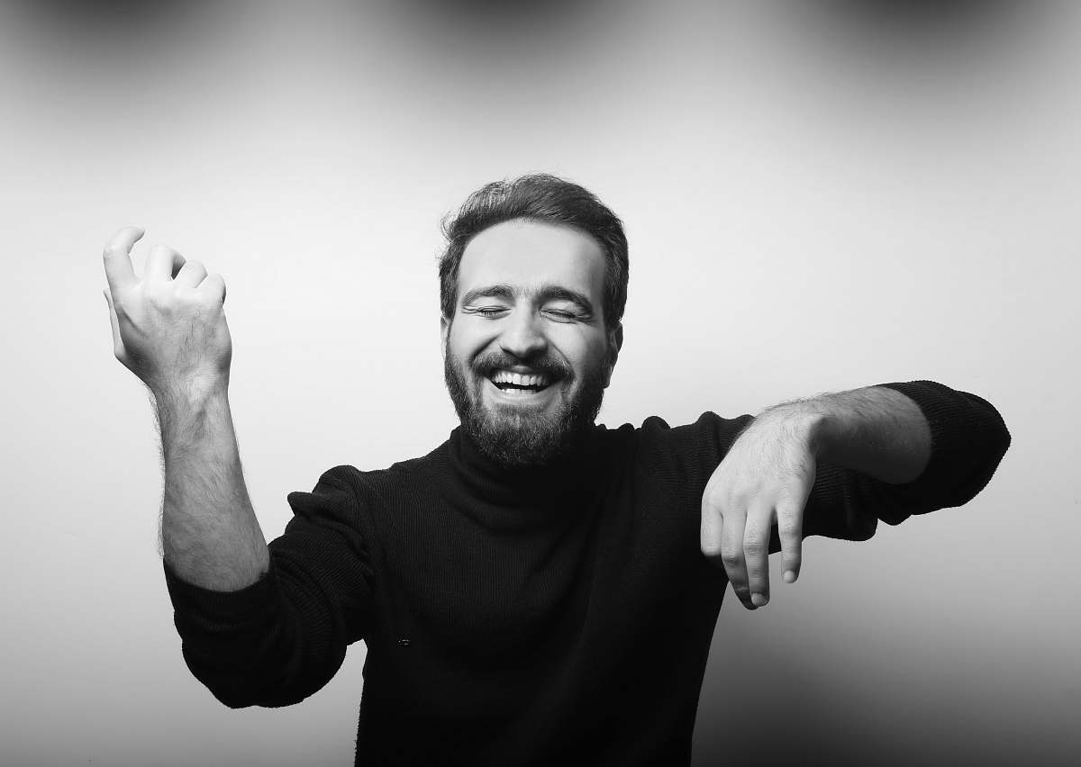 black-and-white grayscale photography of man raising his hands face