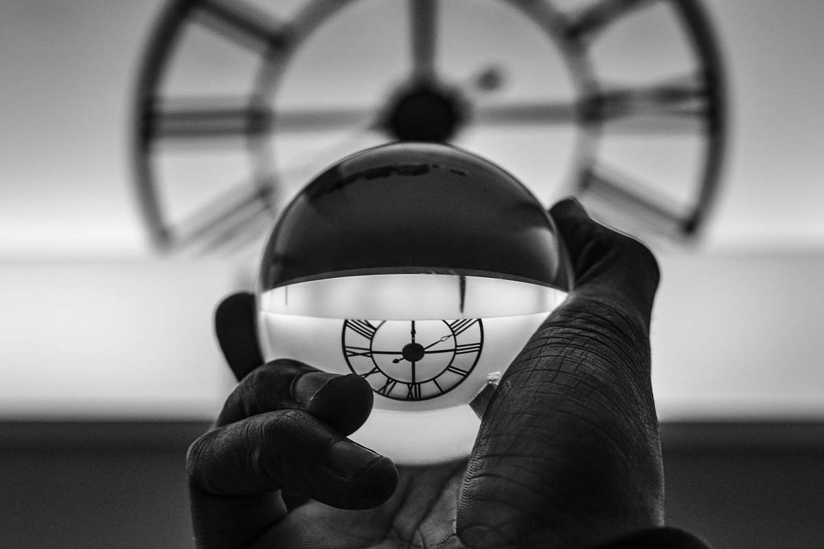 person grayscale photography of person holding glass ball black-and-white