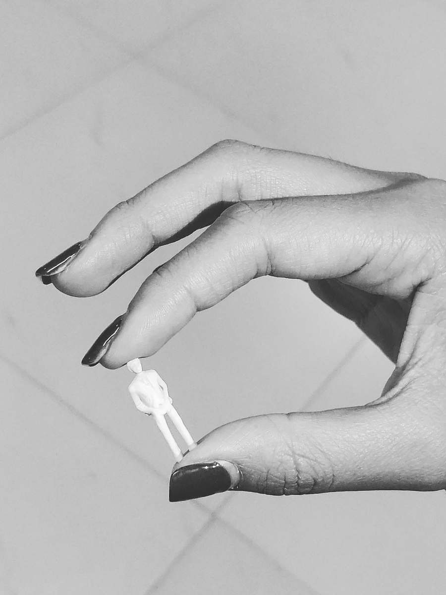 black-and-white grayscale photography of person holding tiny action figure grey