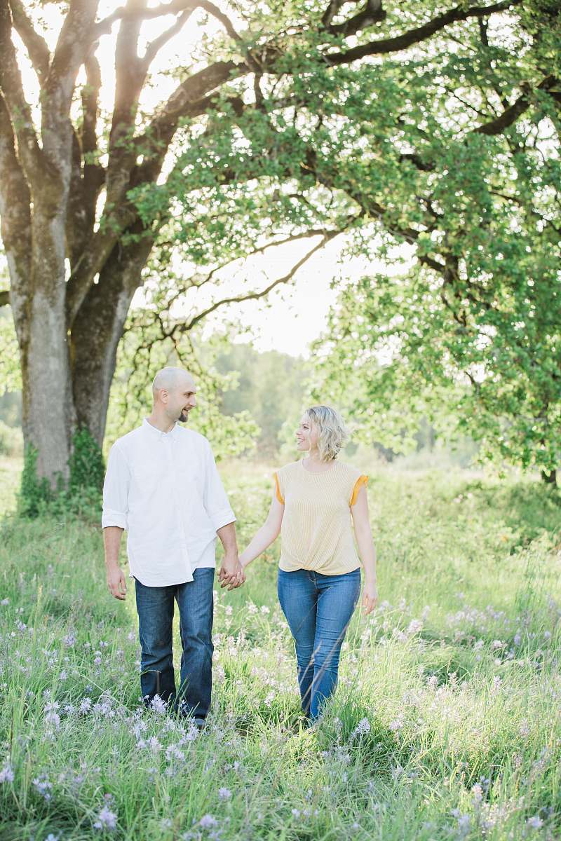 person man and woman holding hands near tree apparel