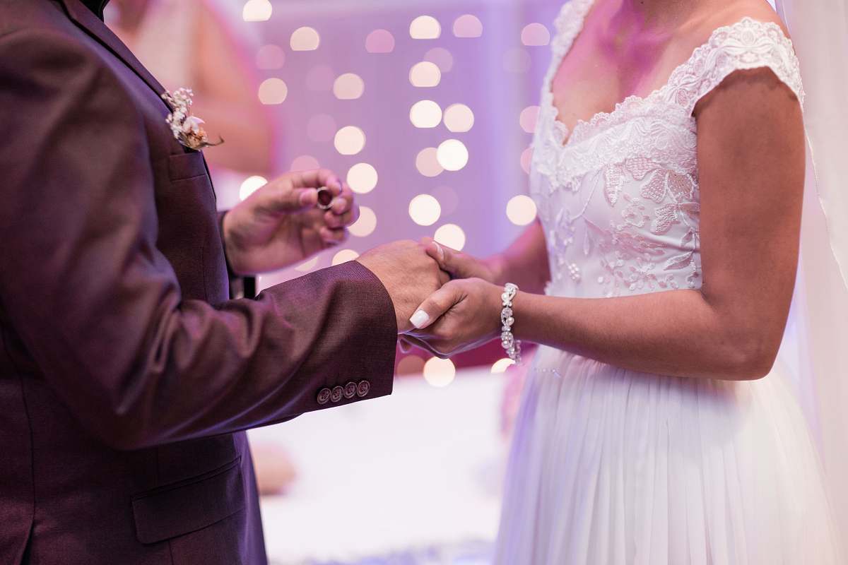 person man holding gold-colored ring hand