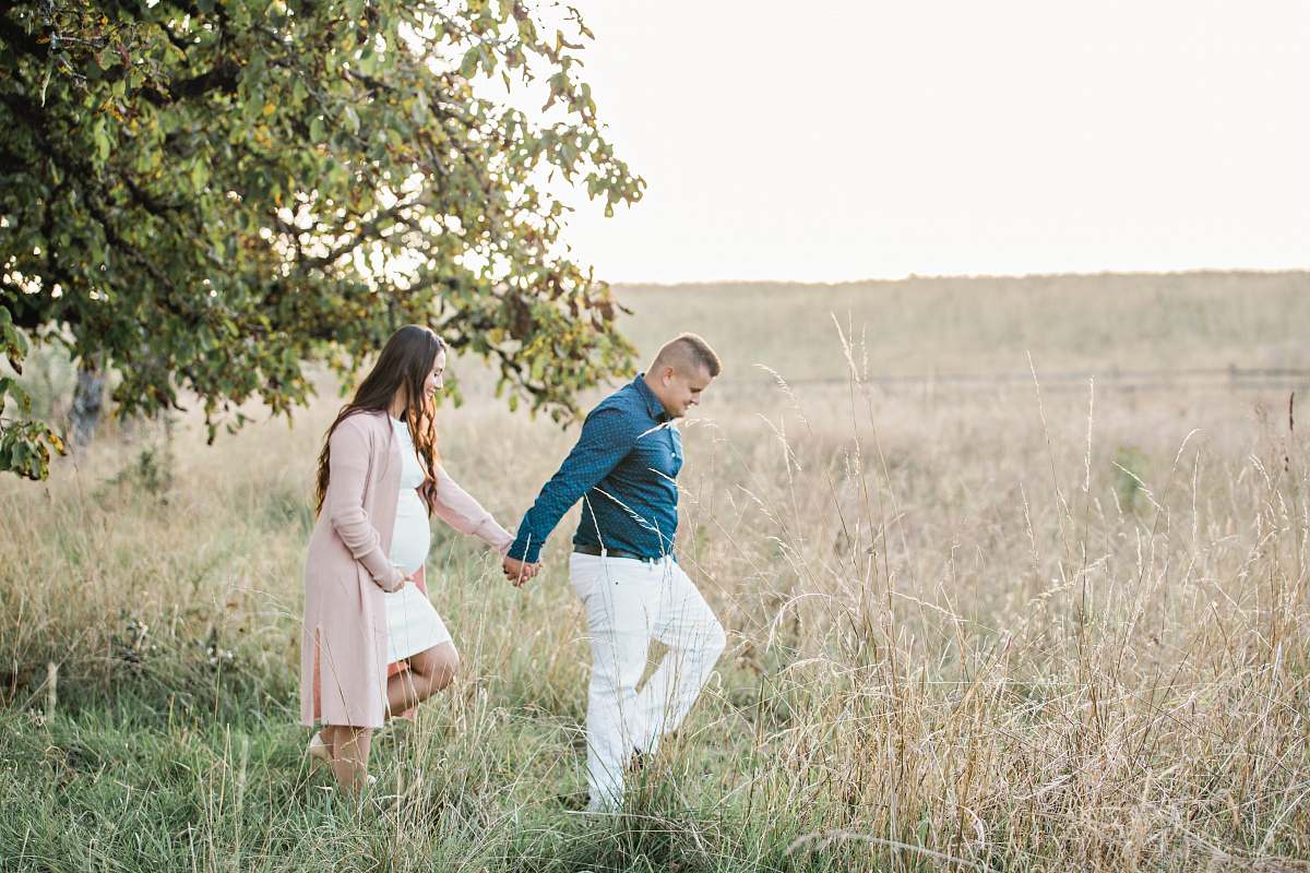 person man in green dress shirt holding woman's hand grass
