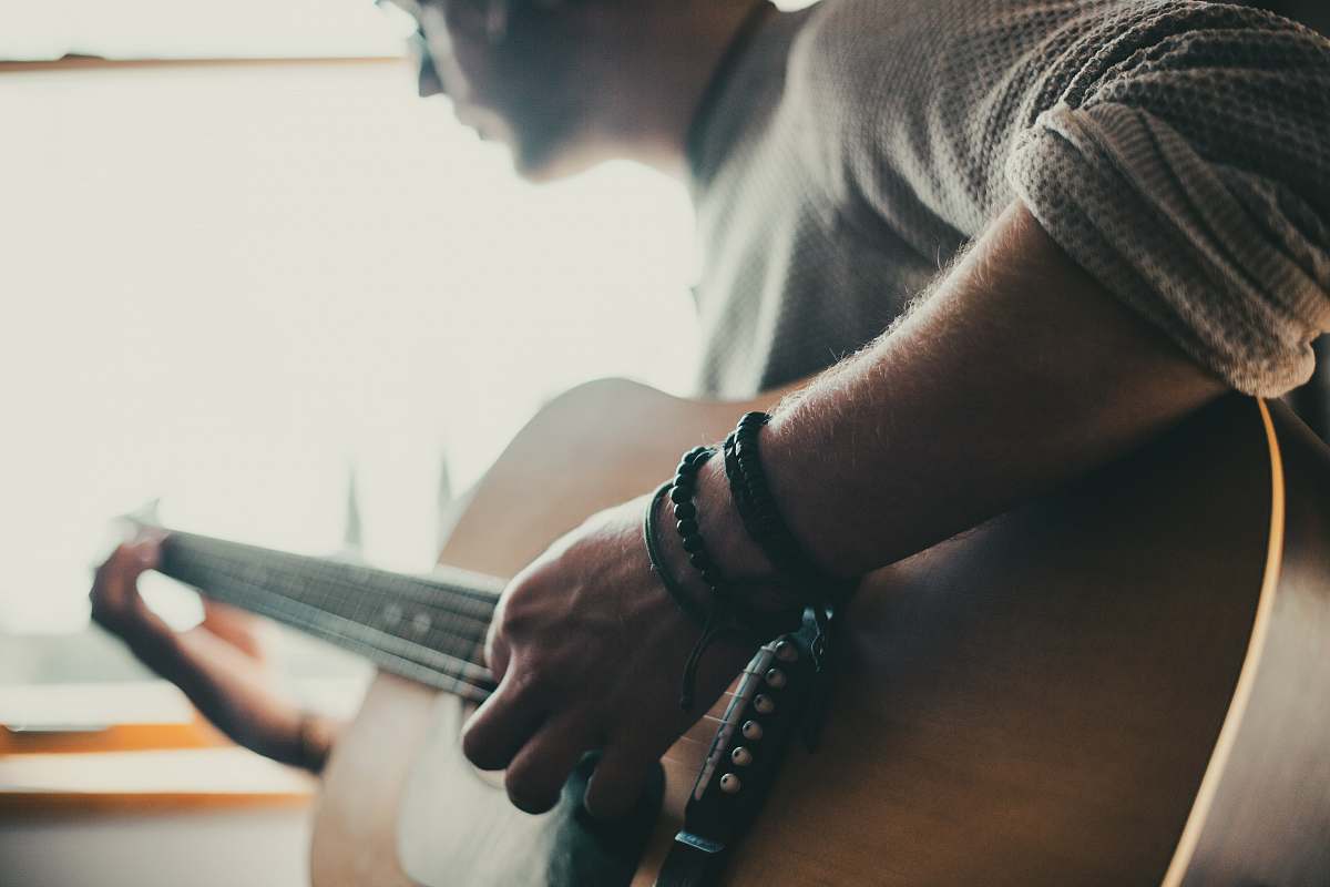 person man playing guitar inside room people