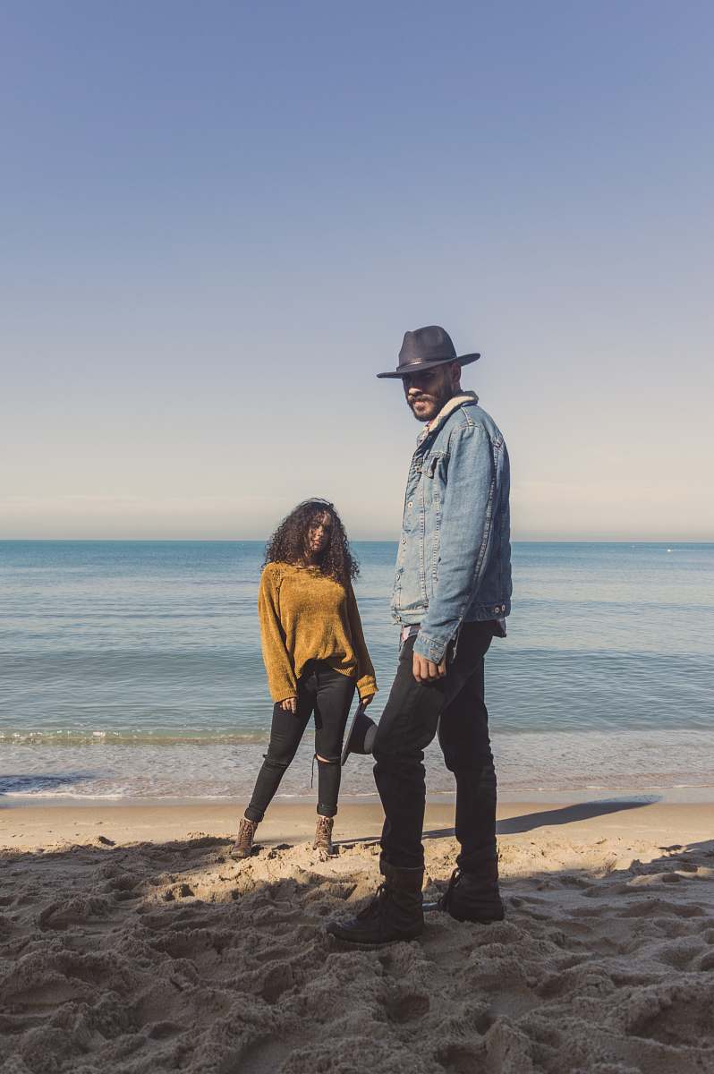 person man standing on seashore near woman clothing