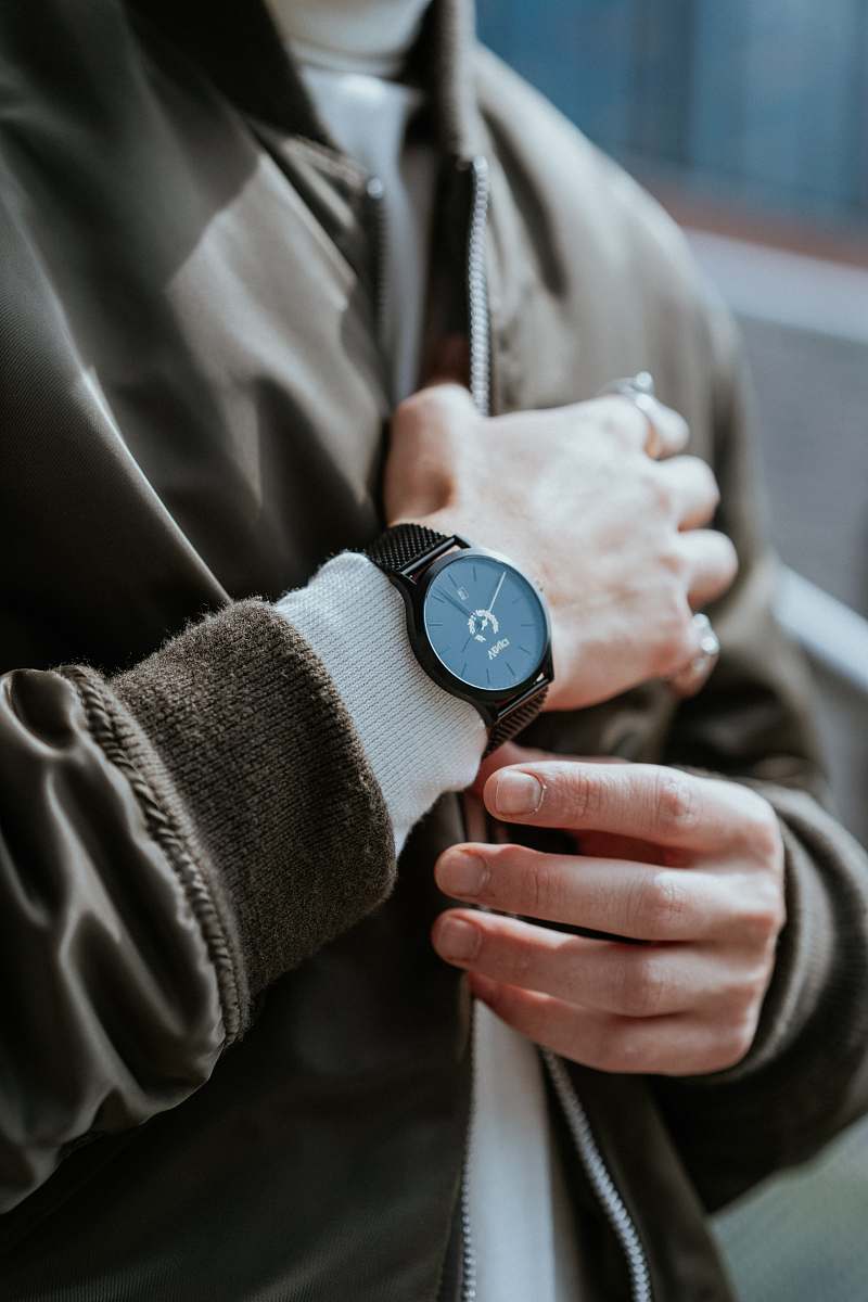 finger man standing while wearing round black analog watch wristwatch
