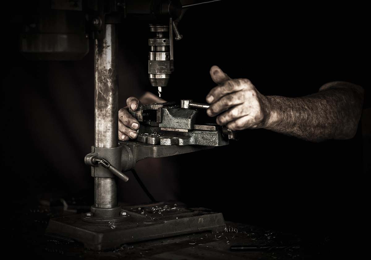 person man using drill press machine