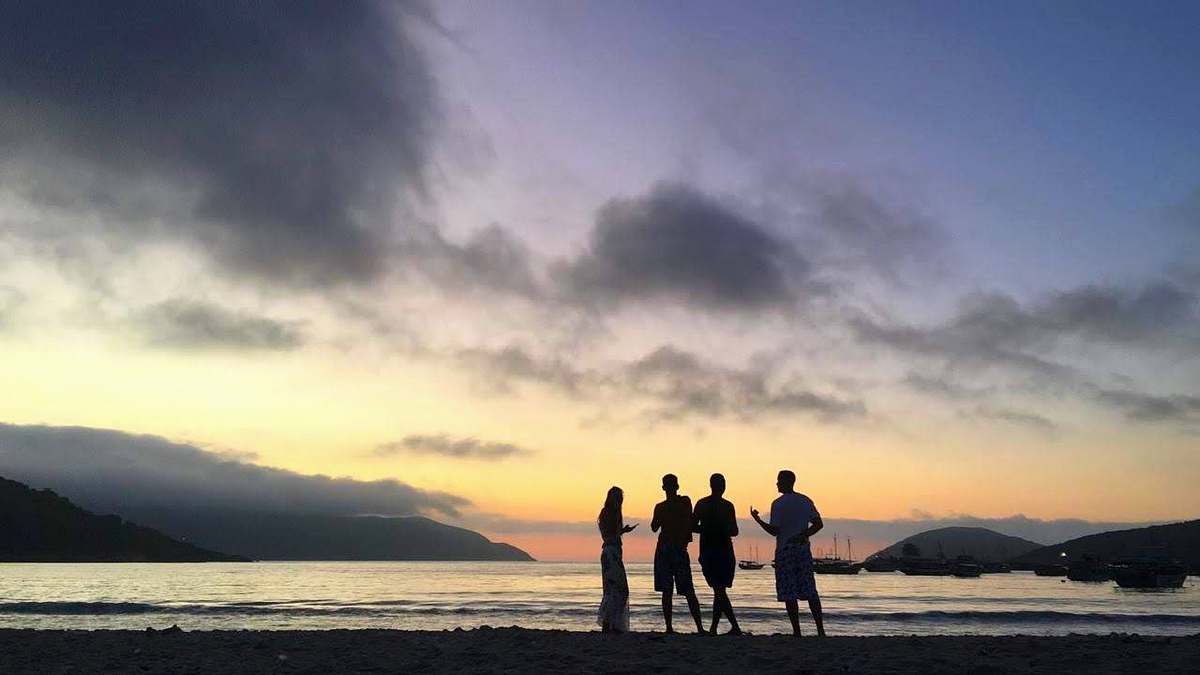 person people standing at the beach during golden hour standing
