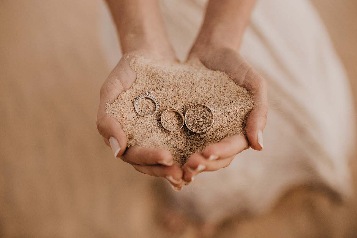 person person hold sand with three rings on top finger