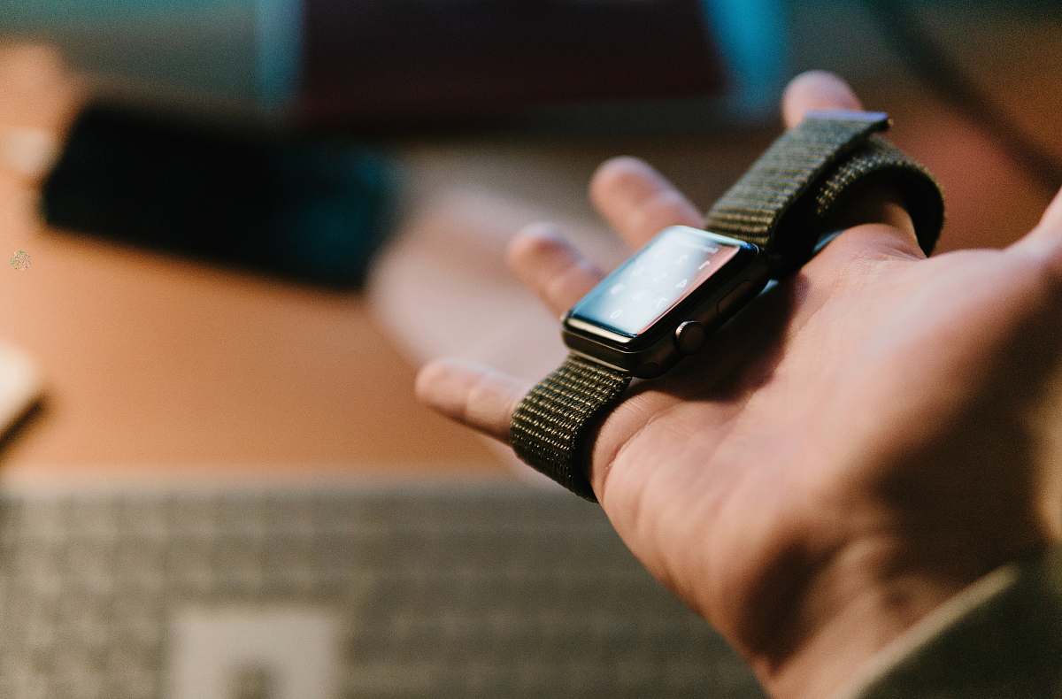 person person holding Apple watch on selective focus photography finger
