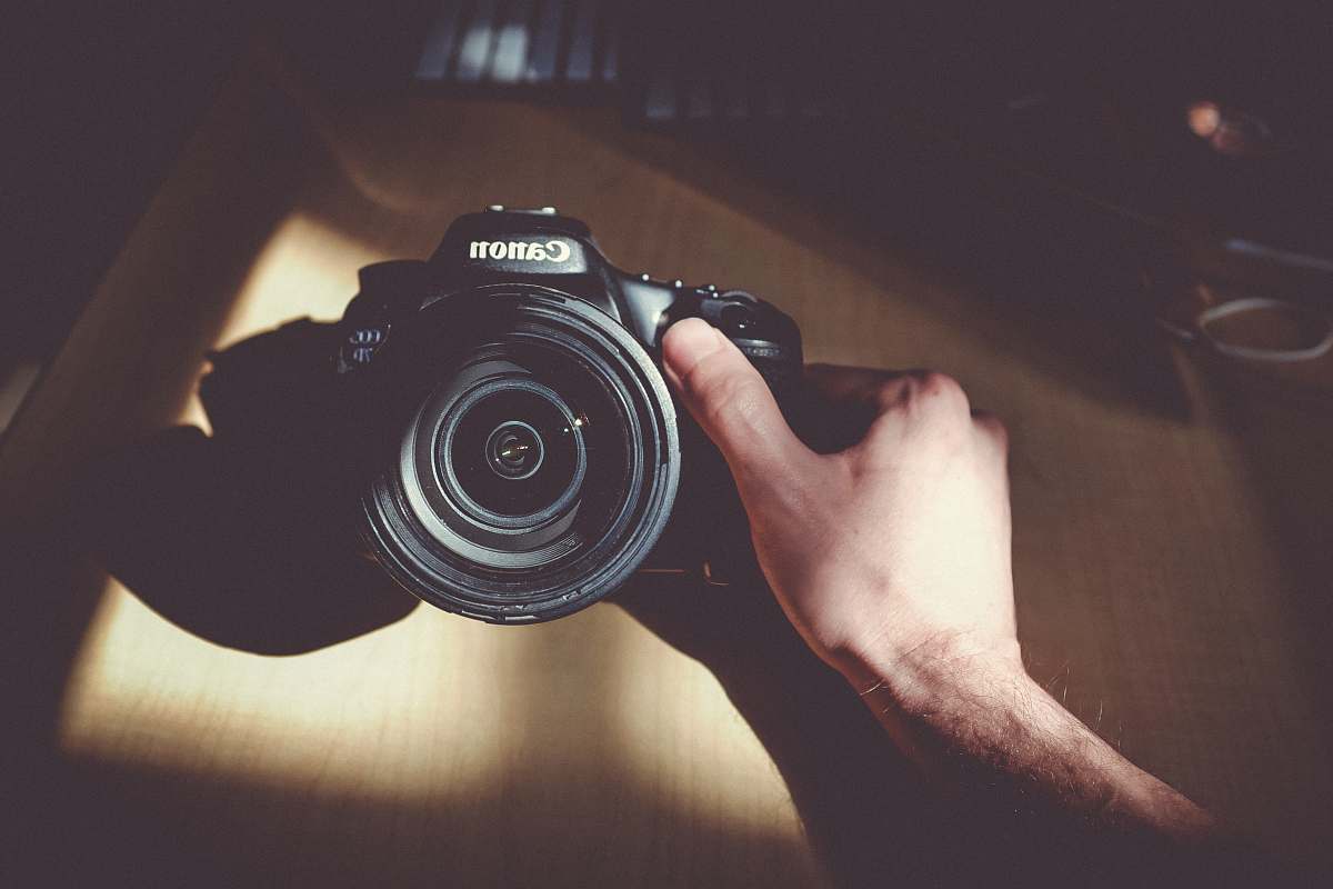 person person holding Canon DSLR camera people