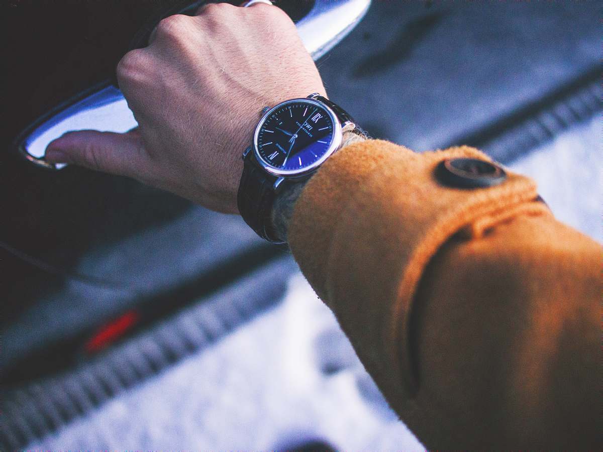 person person holding car door lever wearing round silver-colored watch watch