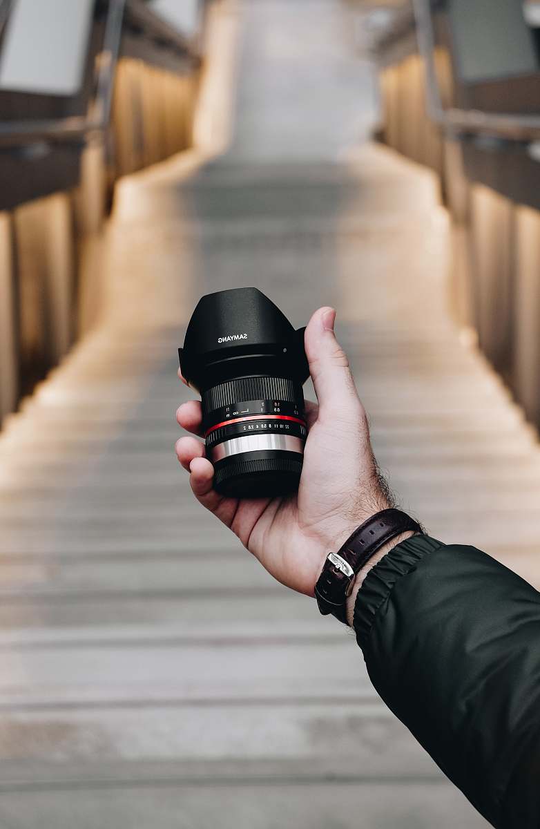 person person holding DSLR camera lens camera
