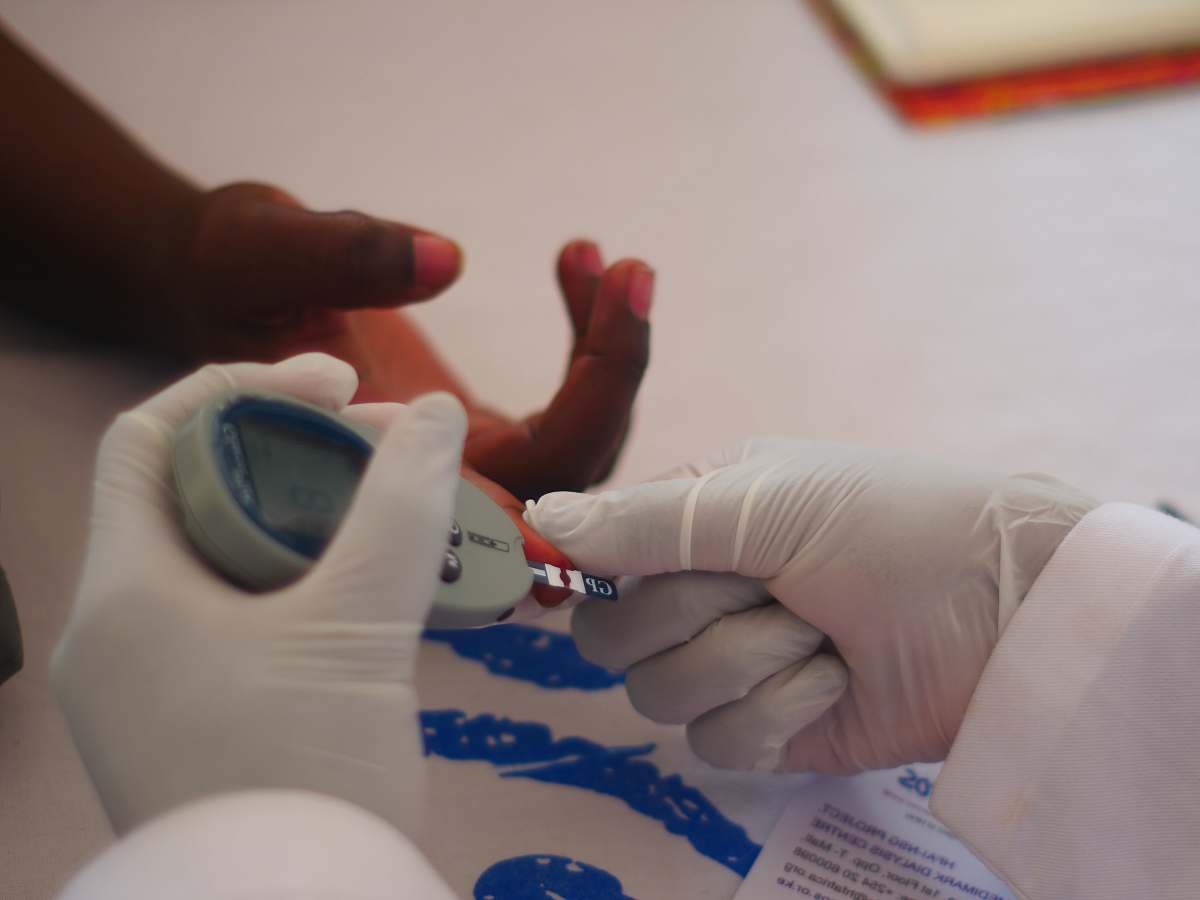 person person holding glucometer hand