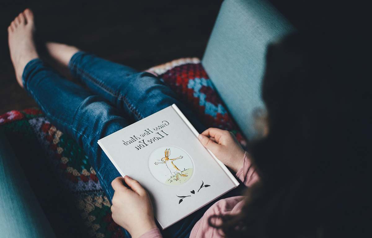 book person sitting on chair reading book kid