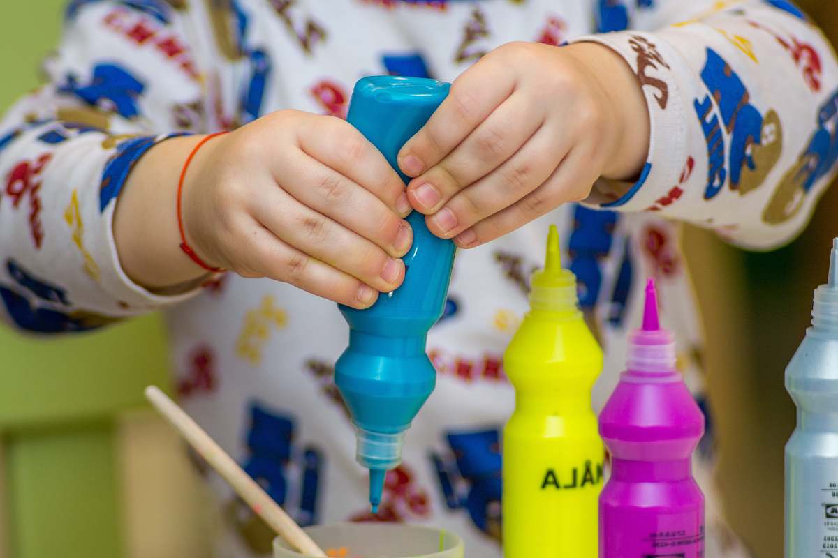 finger person squeezing bottle on a container hand