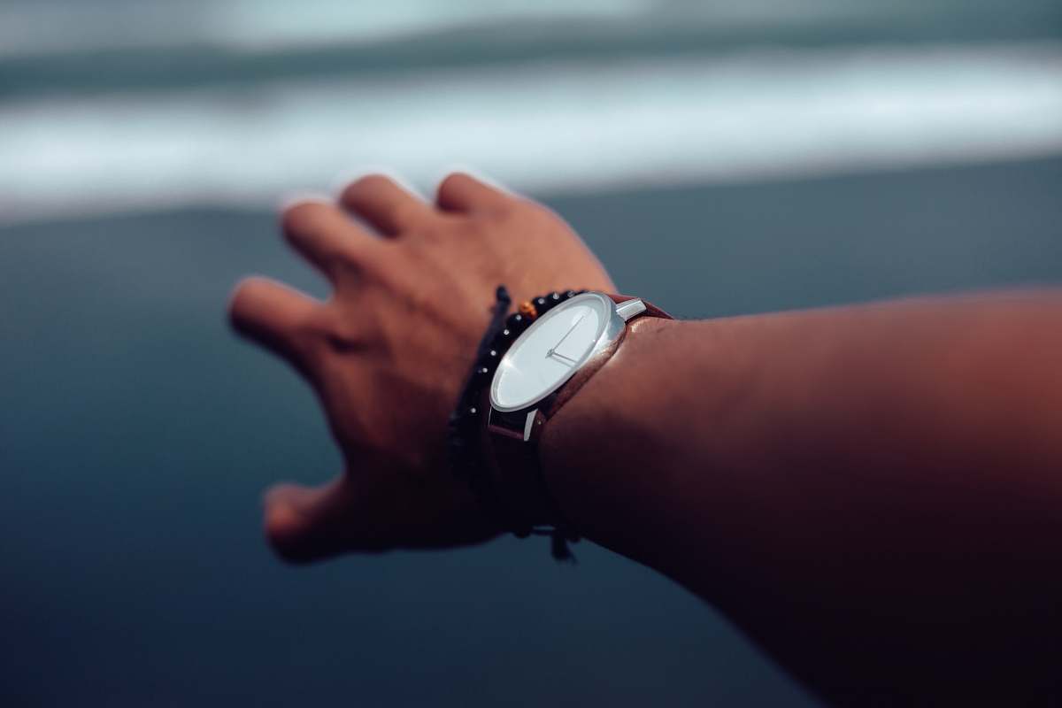person person wearing round silver colored analog watch wristwatch