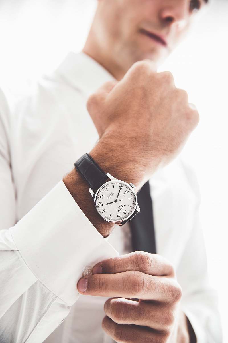 person person wearing round silver-colored analog watch with black leather band wristwatch