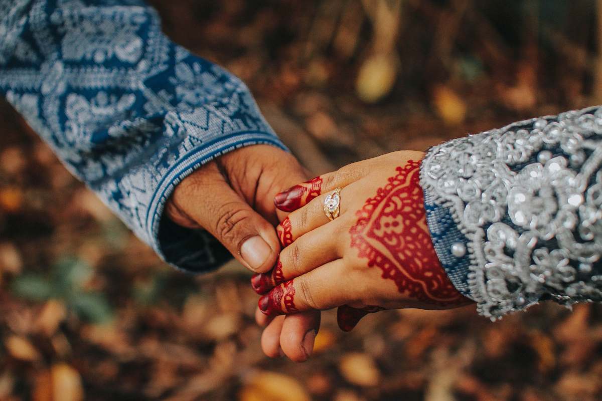hand selective focus photography of man and woman holding hands finger