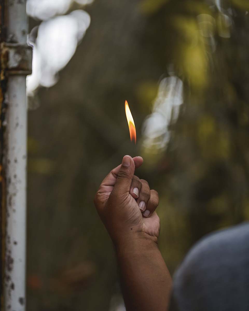 flame shallow focus photography of person's right hand fire