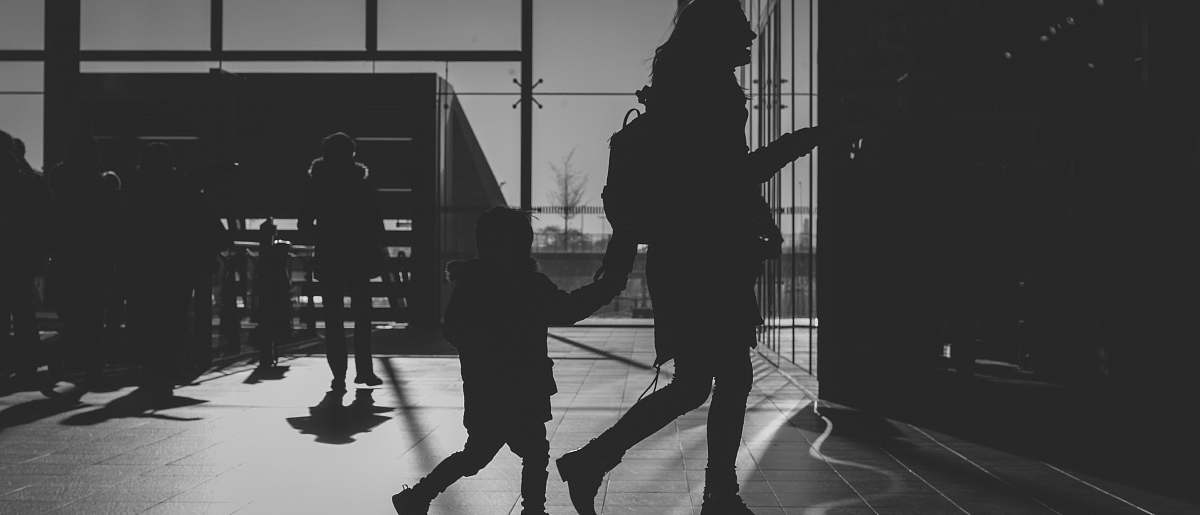 black-and-white silhouette of woman holding child grey
