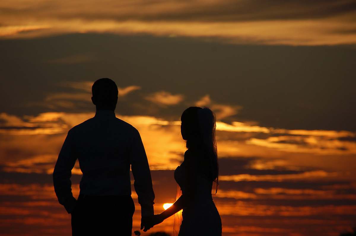 person silhouette photography of of man and woman standing hand