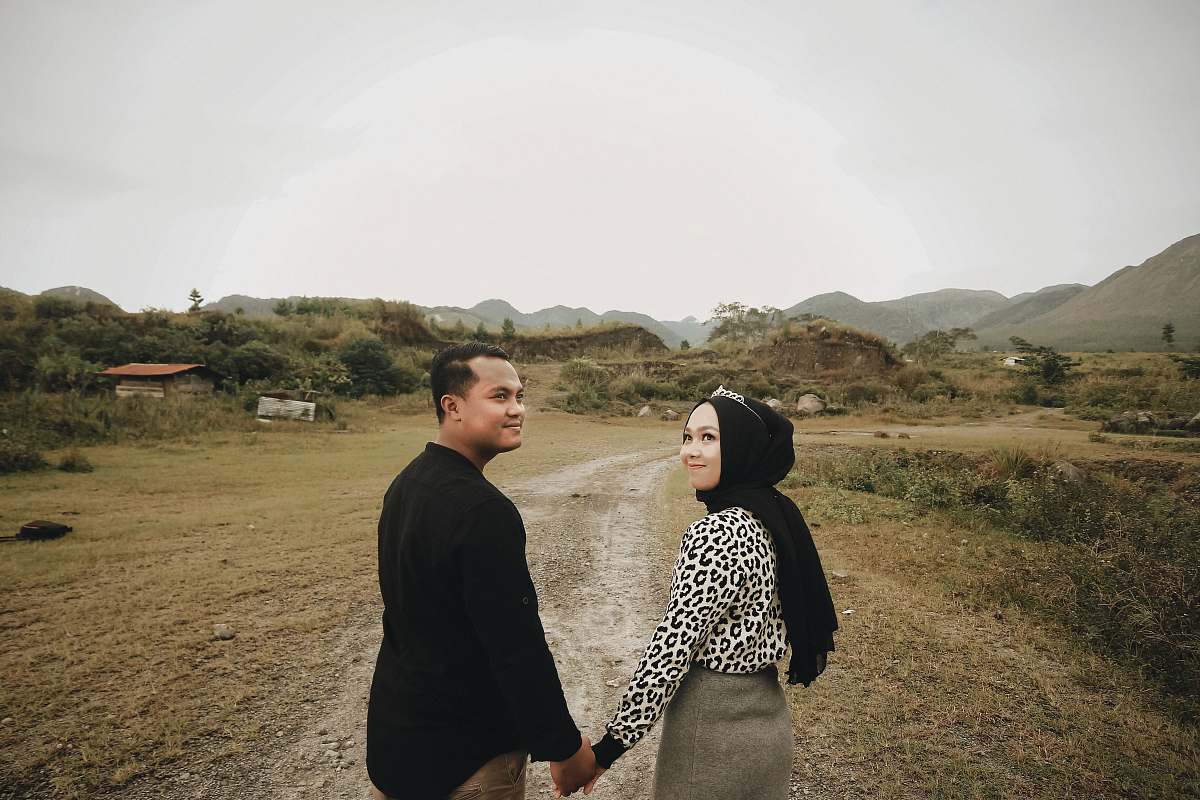 apparel smiling woman and man holding hands while walking clothing