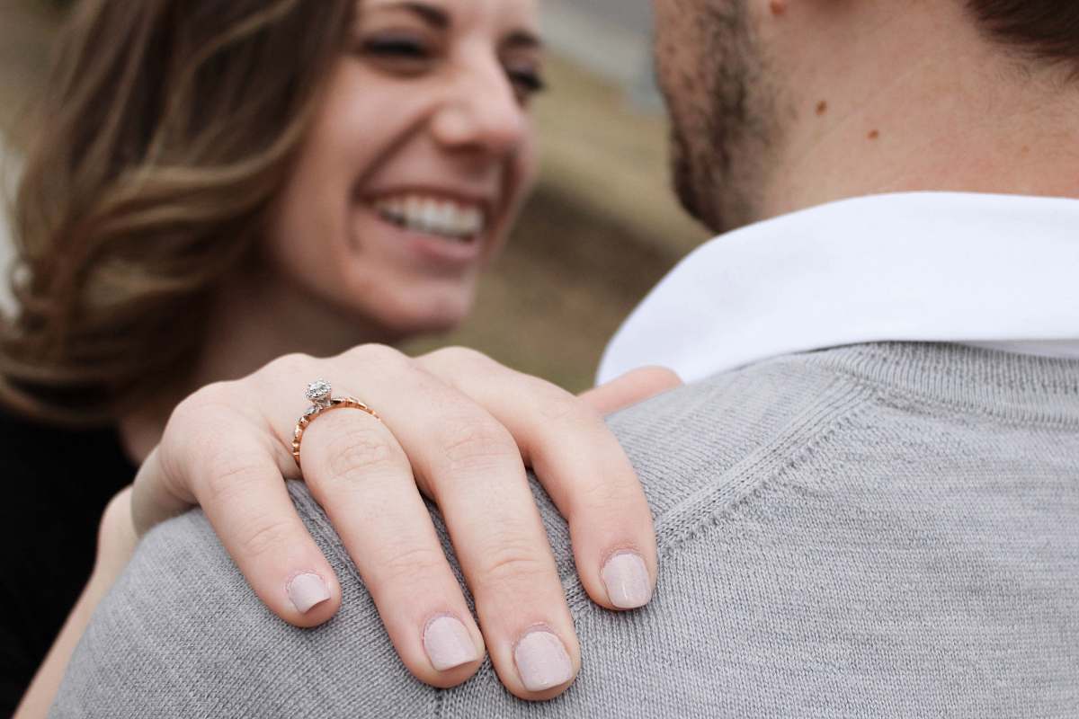 person smiling woman grabbing man's shoulder hand