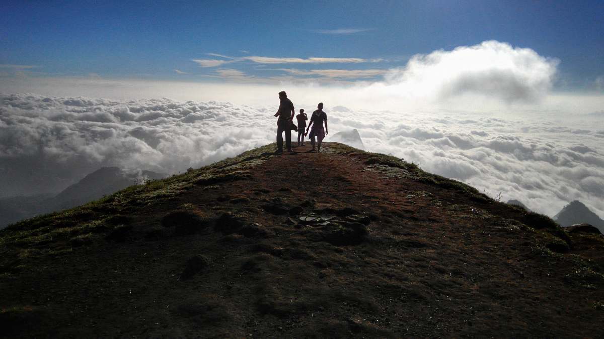person three person on mountain peak with sea of clouds outdoors