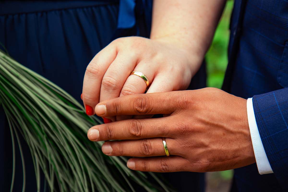 person two person with gold wedding bands in hands finger