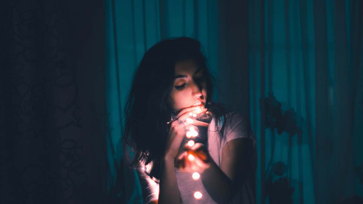 person woman holding LED string light people