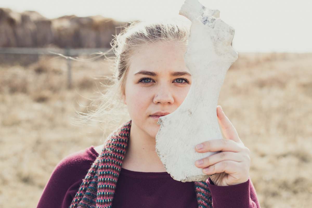 person woman holding white animal bone people