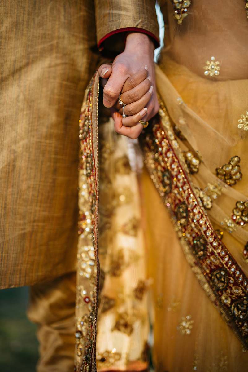 people selective focus of two person holding hands sari