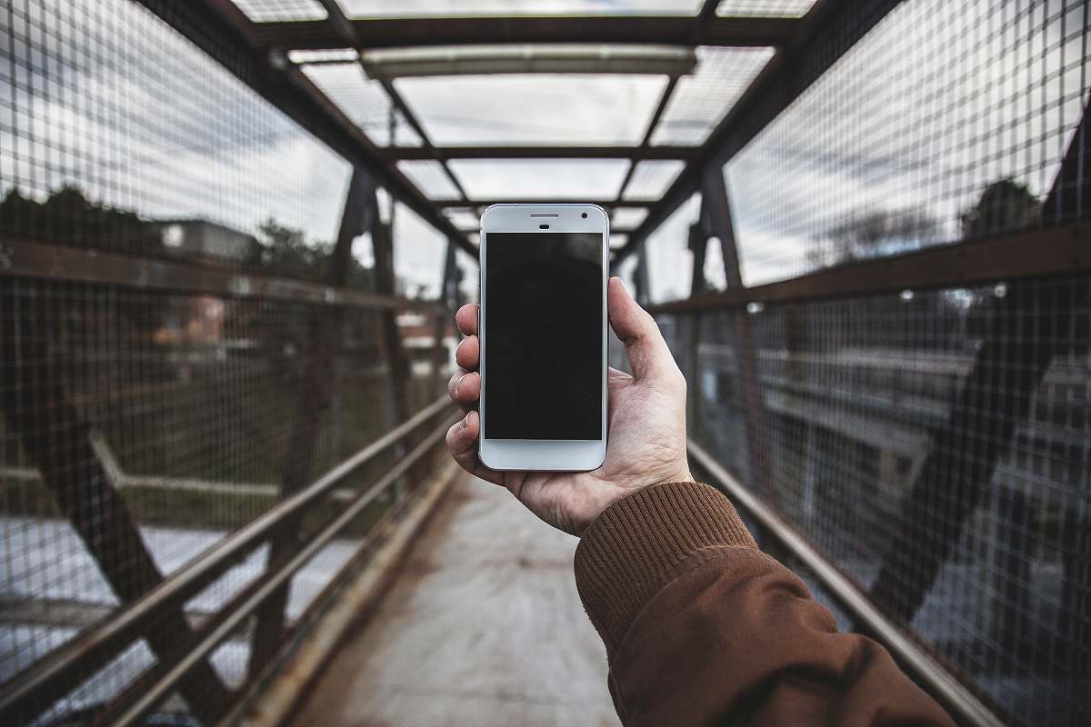 hand person holding white smartphone phone
