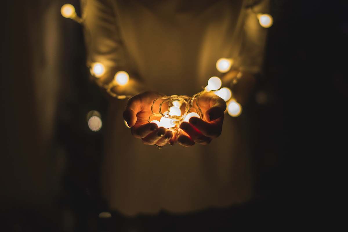 christmas person holding string lights hands