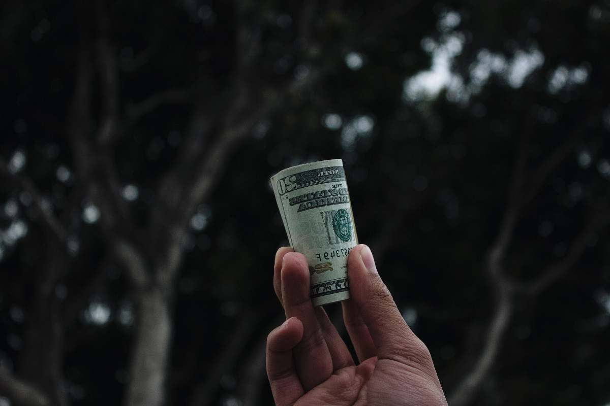 ticket person holding U.S. dollar banknote text