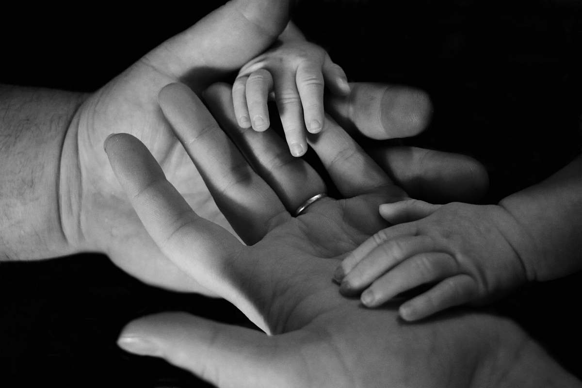 black-and-white babys hand on human palm family