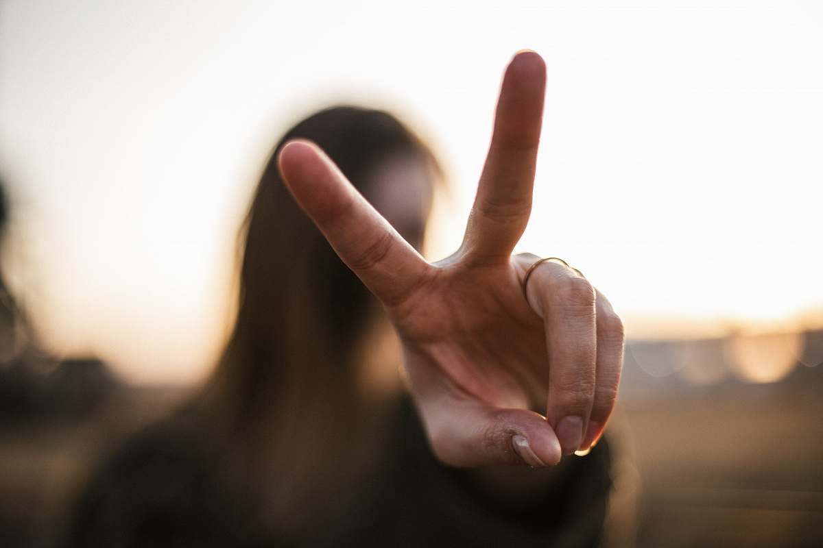 hands focus photography of woman hand with peace sign fingers