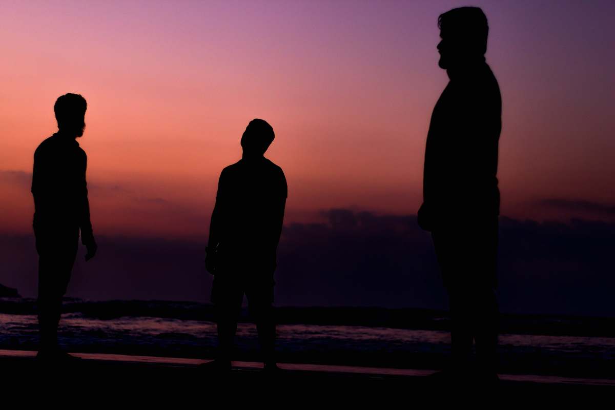 human silhouette of tree person near seashore during sunset silhouette