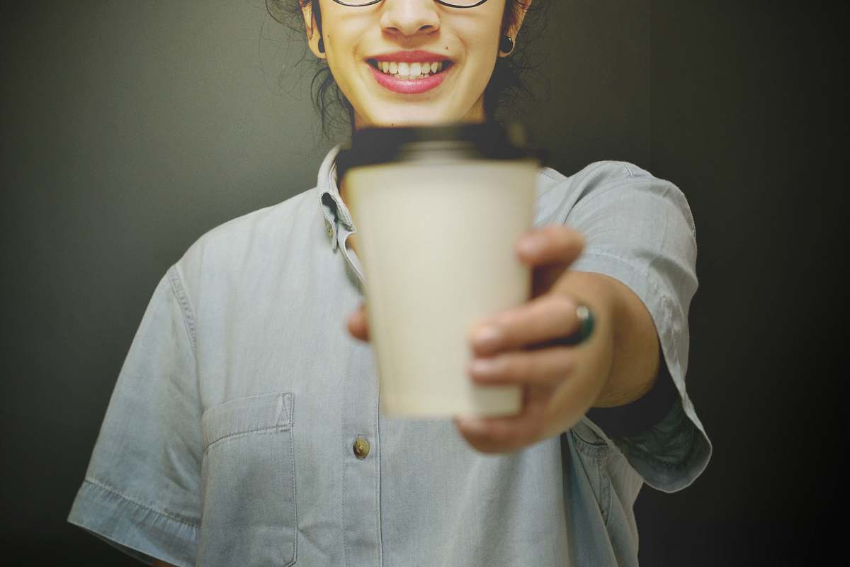 human woman holding white and black coffee cup person