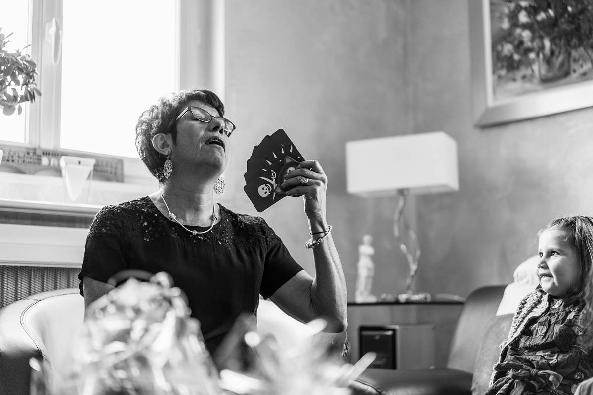 human woman in black t-shirt holding playing cards black-and-white