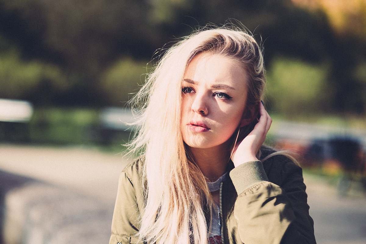 girl woman touching her hair near trees woman