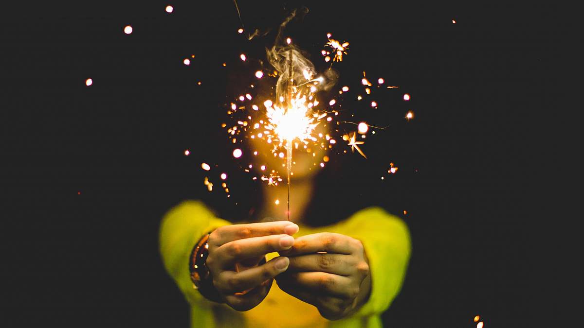 woman woman wearing green shirt holding sparkler spark