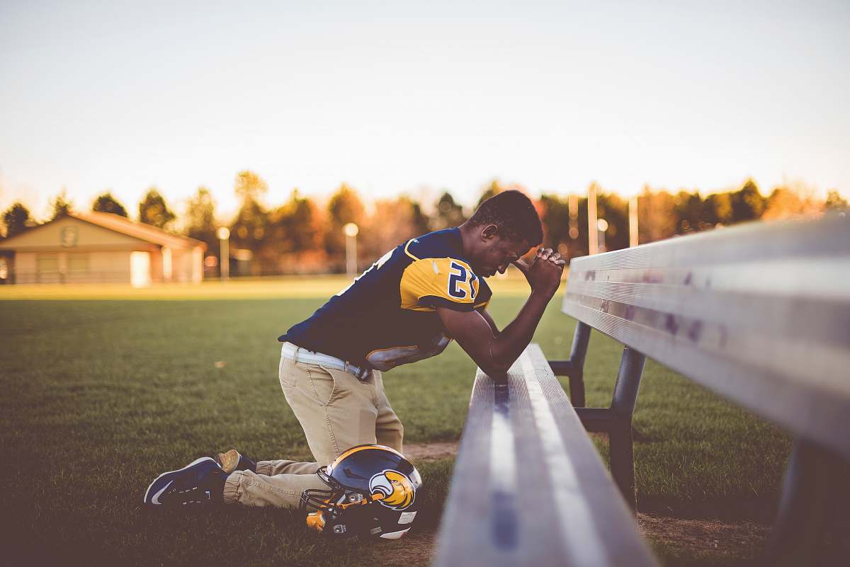 people baseball player kneeling on ground bench