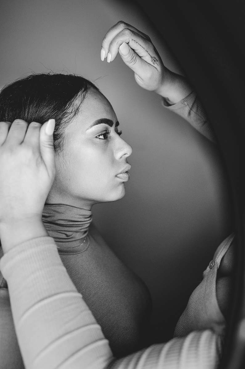 black-and-white grayscale photo of person holding woman's hair human